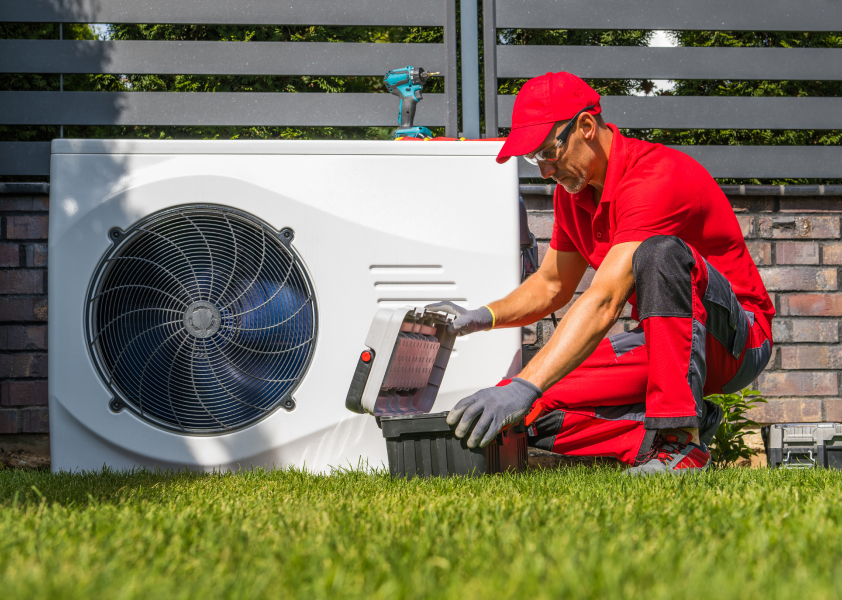 HVAC technician working on an air conditioner. Choose a licensed contractor before buying an air conditioner