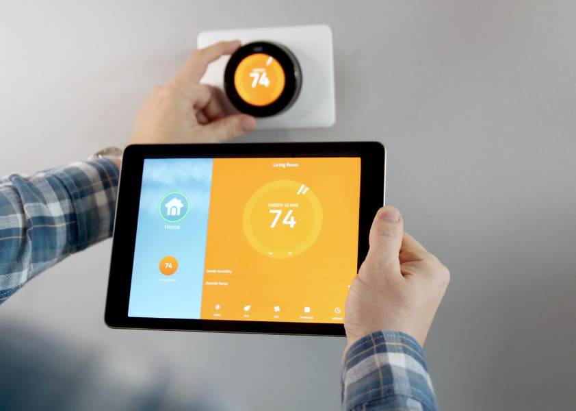 A person setting a thermostat
