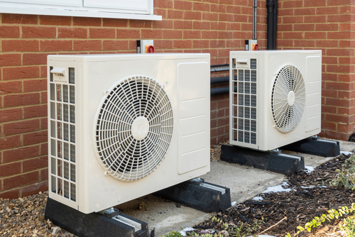 Two air source heat pumps installed on the exterior of a house