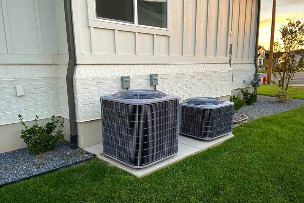 Double AC units outside white brick home